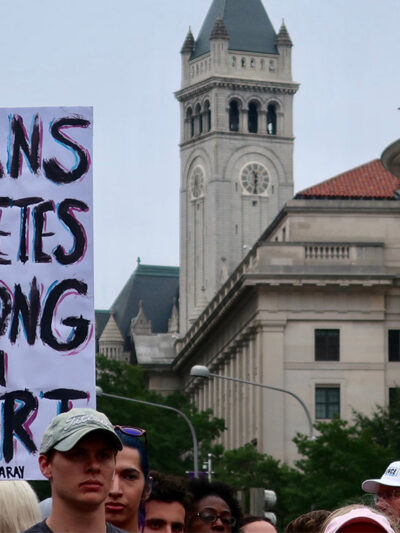 Image of a protest sign that reads "Trans athletes belong in sports"