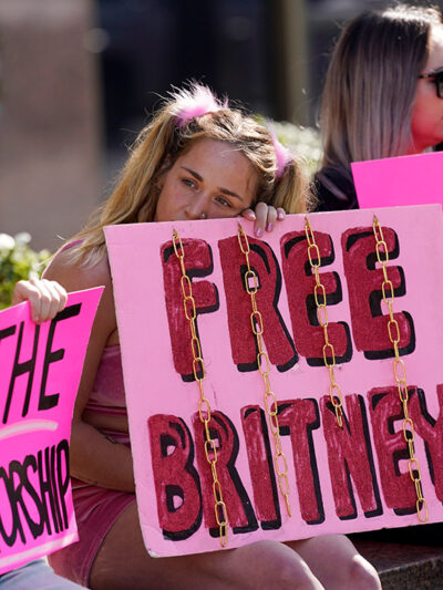 Britney Spears' supporters sit outside holding signs that read "Free Britney" and "End the Conservatorship" during a court hearing concerning the pop singer's conservatorship