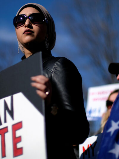 Image of a protester holding a sign that read, "BAN HATE."