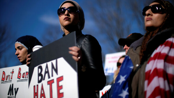 Image of a protester holding a sign that read, "BAN HATE."