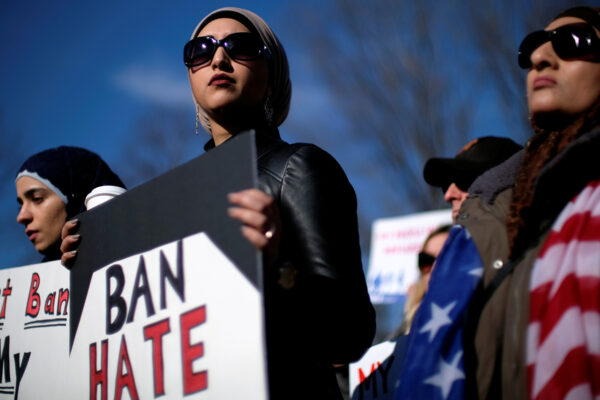 Image of a protester holding a sign that read, "BAN HATE."