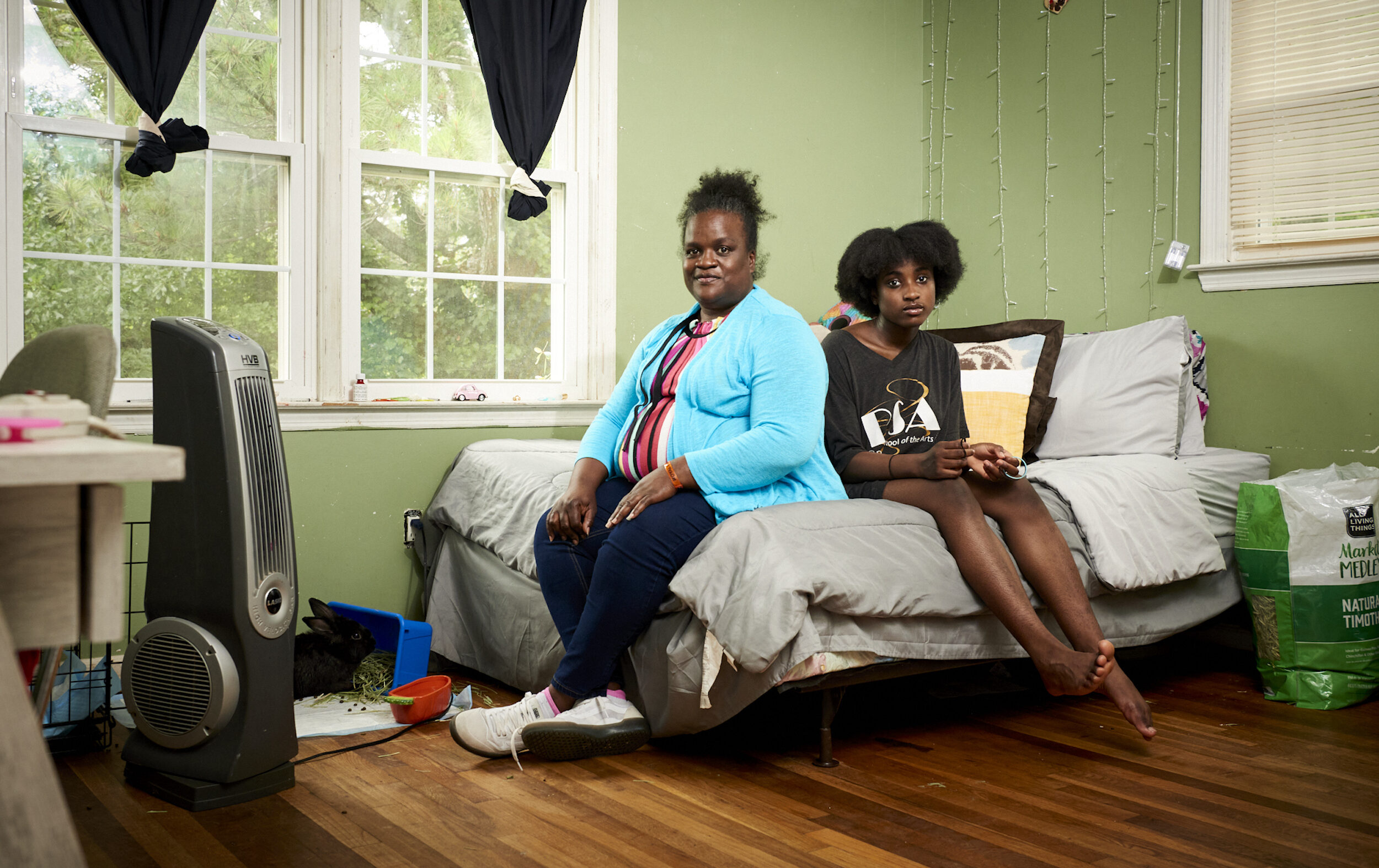 Mother and child sitting on a bed in a bedroom