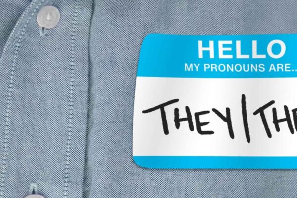 Image of a shirt with a pronoun tag that reads, "they/them"