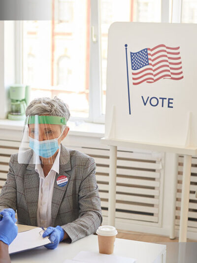 Image of poll workers helping people vote
