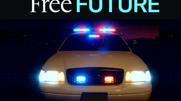 A frontal view of a police car with its lights on at night