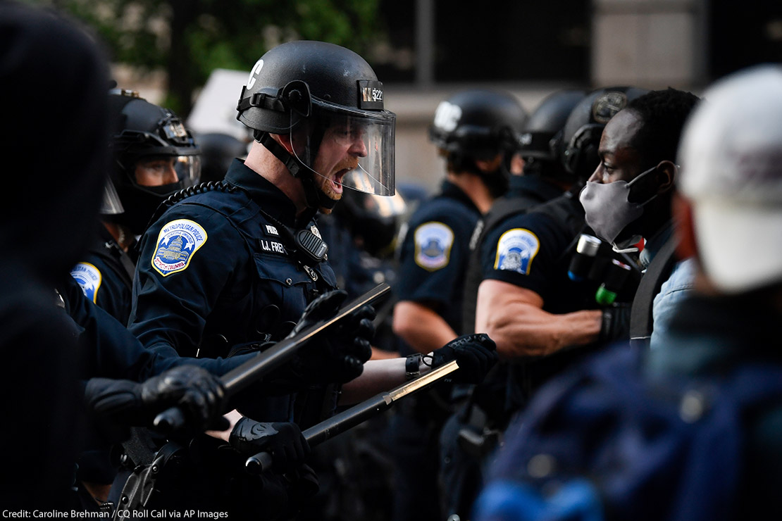 Police in riot gear shouts in black protestor's face as demonstrators gather to protest the death of George Floyd near the White House