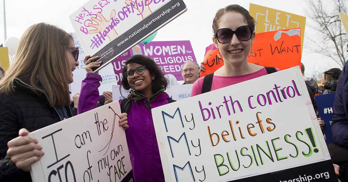Image of a person holding a sign that reads, "My birth control, my beliefs, my business."