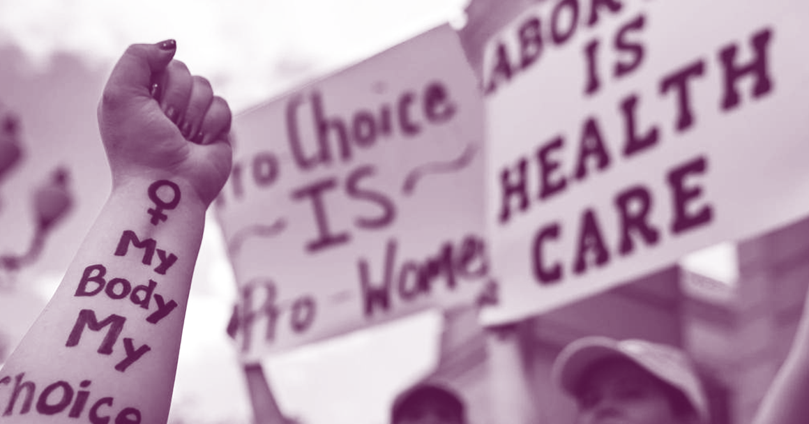 Image of protest signs and an arm that has the text, "My body my choice." 