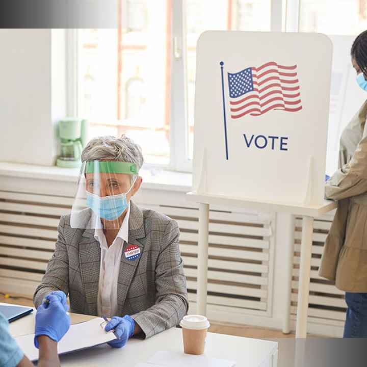 Image of poll workers helping people vote
