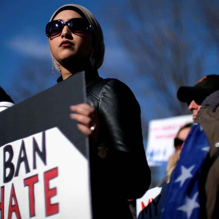 Image of a protester holding a sign that read, "BAN HATE."